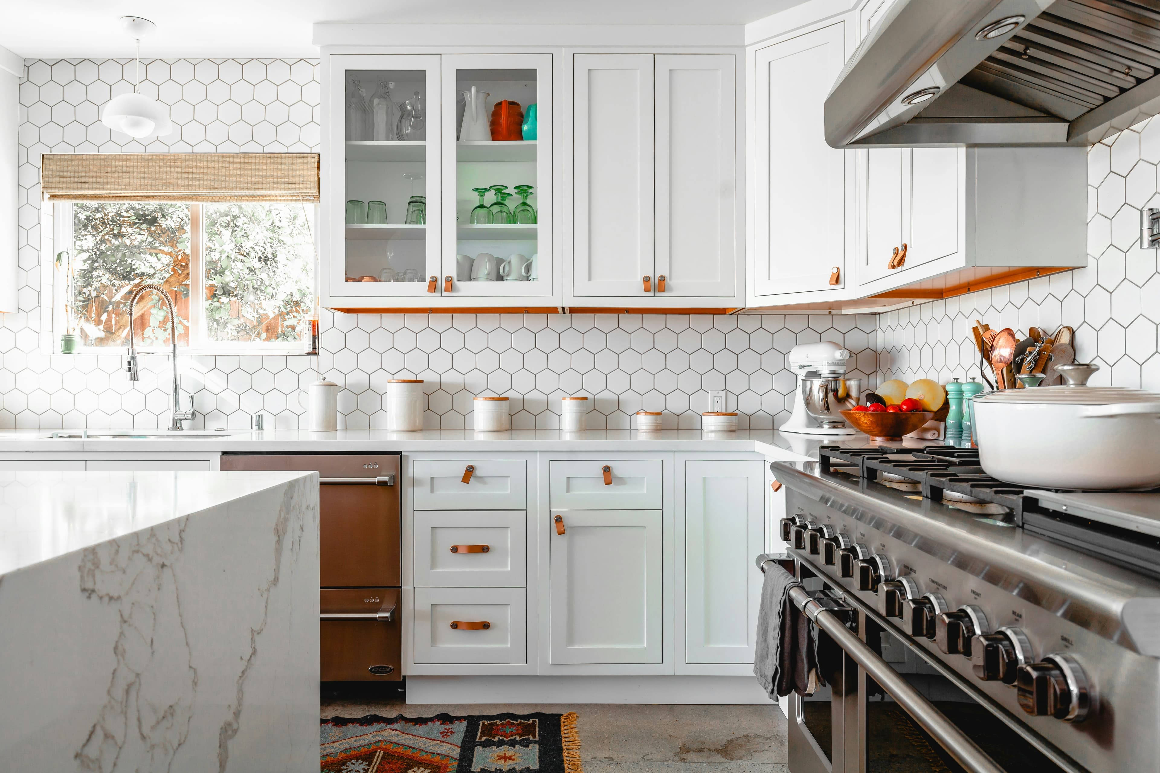 Modern handleless custom kitchen with warm wood cabinetry and marble countertops