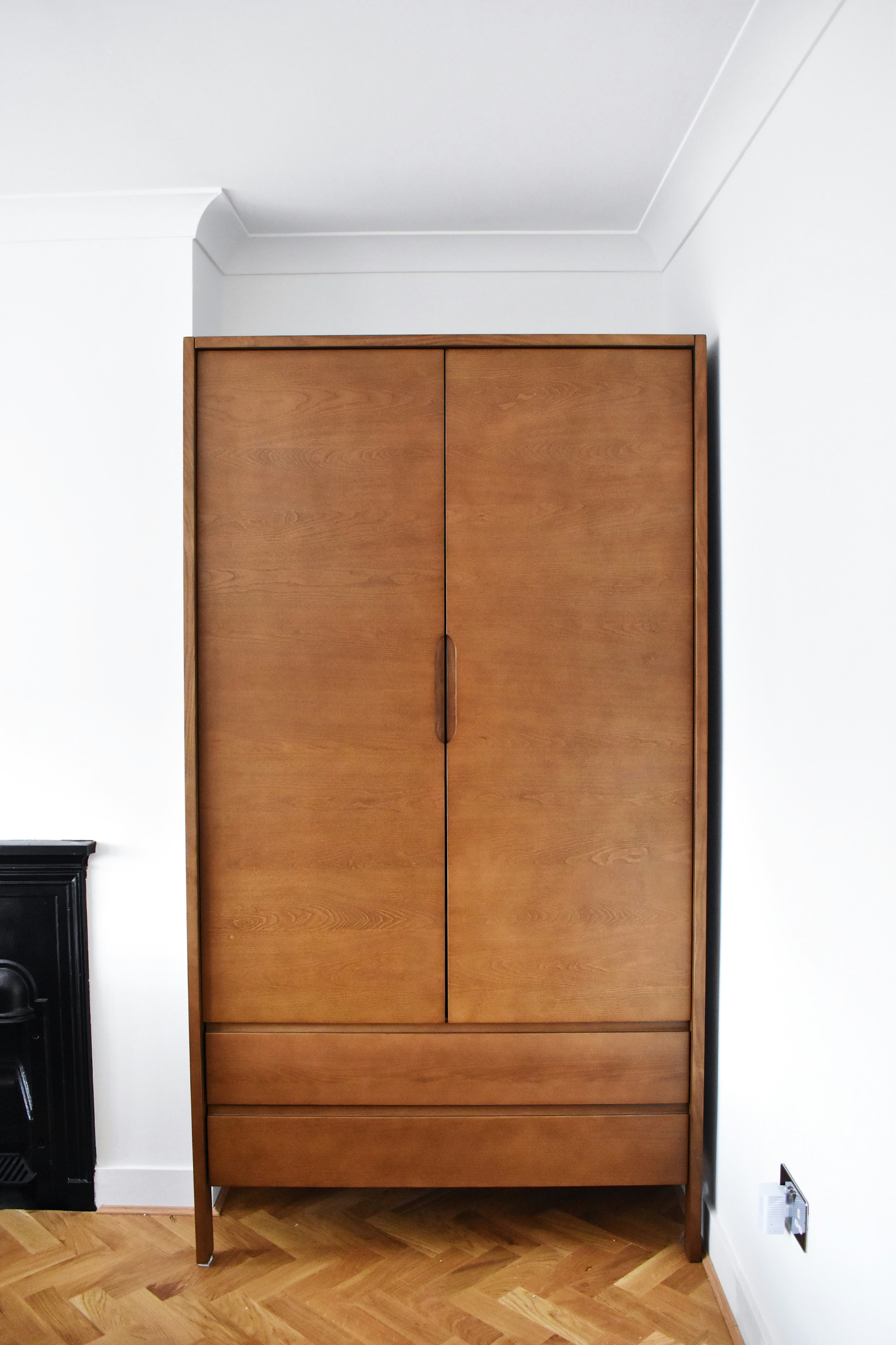 Walk-in closet with backlit shelving, custom organization, and warm wood cabinetry